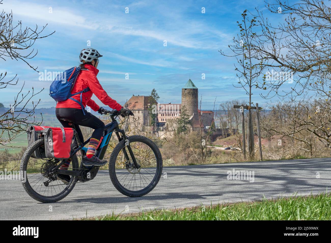 Belle ville femme lors d'une visite à vélo sur la célèbre route allemande des châteaux, en face du château médiéval de Colmberg, Franconie, Bavière, Allemagne Banque D'Images