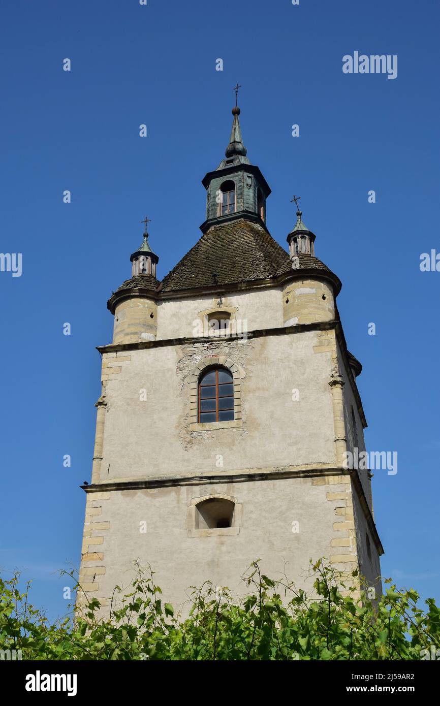 Grande tour médiévale en pierre avec fenêtres et croix dans plusieurs niveaux. Au-dessous de la végétation verte Banque D'Images