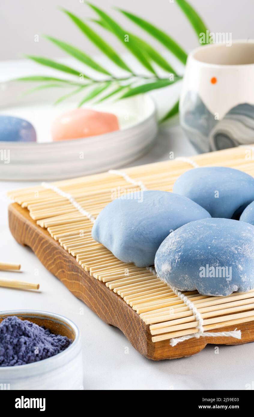 Un mochi japonais couché sur un tapis en bois sur un comptoir blanc. Concept d'un dessert japonais traditionnel sur la table de cuisine. Gâteau de riz asiatique Banque D'Images