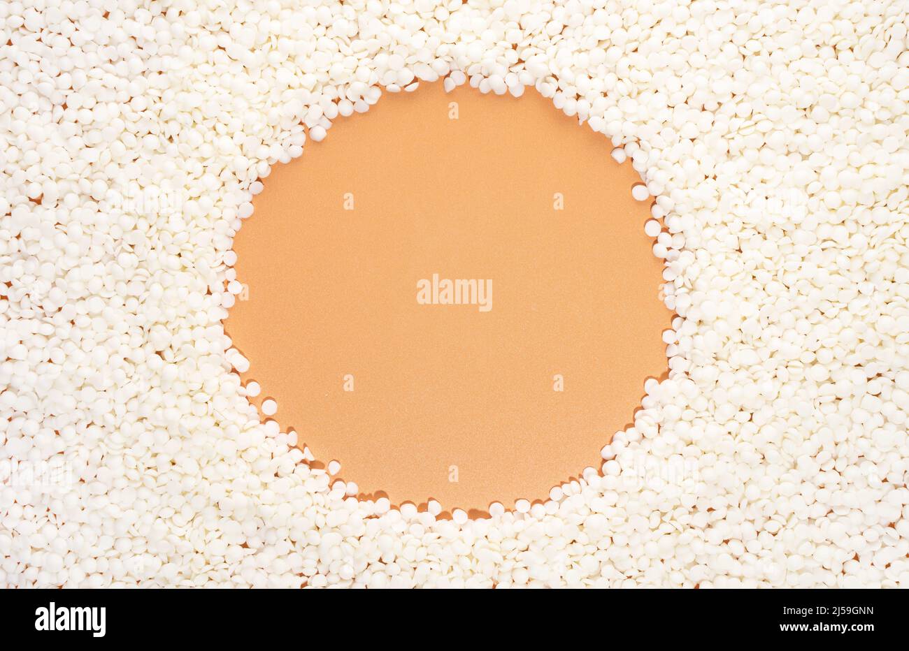 Cire de soja biologique sur fond beige avec espace de copie pour le design, texte. Vue de dessus. Rond, une bordure de cadre de cercle de cire vegan. Créer une maquette d'espace de copie vierge Banque D'Images
