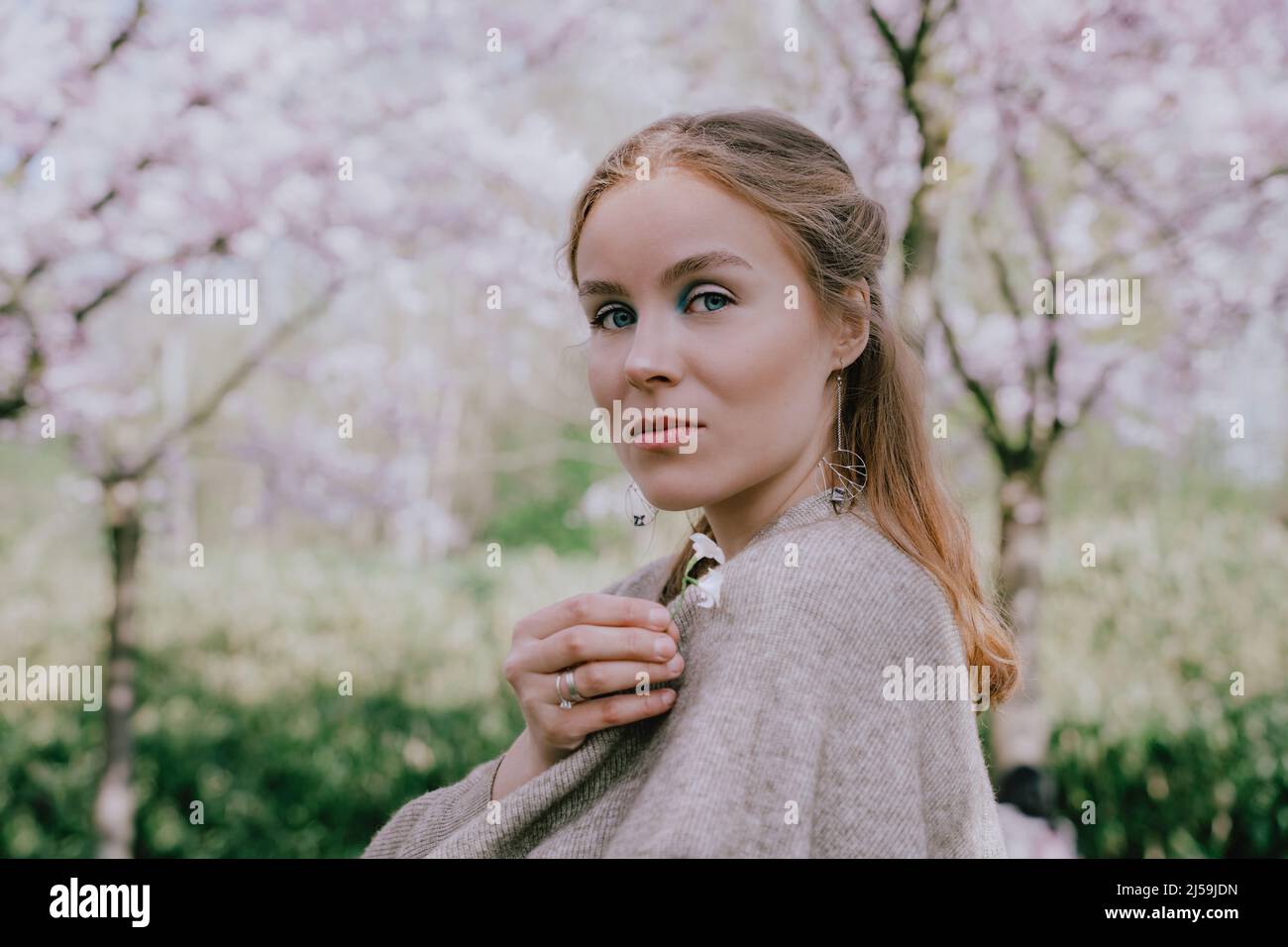 Femme appréciant la nature au printemps. Détendez-vous sous les cerisiers en fleurs. Femme profitant de la vie, marchant dans le parc avec des cerisiers en fleurs. Concept de bonheur Banque D'Images