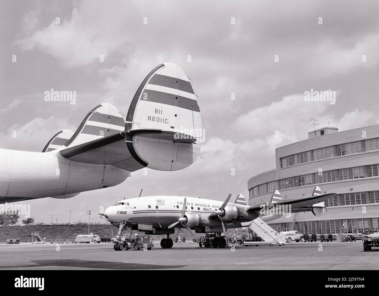 1950S SIGNATURE TRIPLE FIN QUEUE D'AVIONS DE CONSTELLATION TWA 4 HÉLICES À MOTEUR SUR LE TARMAC À L'AÉROPORT - A89 CRS001 HARS GRAND ANGLE HÉLICE AVENTURE AVIONS SERVICE CLIENT EXTÉRIEUR BAS ANGLE PUISSANT PROGRÈS FIN INNOVATION FIERTÉ TARMAC AVIATION OCCUPATIONS ESCALIER TRIPLE 1943 CONSTELLATION CONCEPTUELLE SIGNATURE ÉLÉGANT TWA LOCKHEED TRANS WORLD AIRLINES AVION CIVIL NOIR ET BLANC EMBLÉMATIQUE DE L'ANCIEN STYLE ÉLÉGANT Banque D'Images