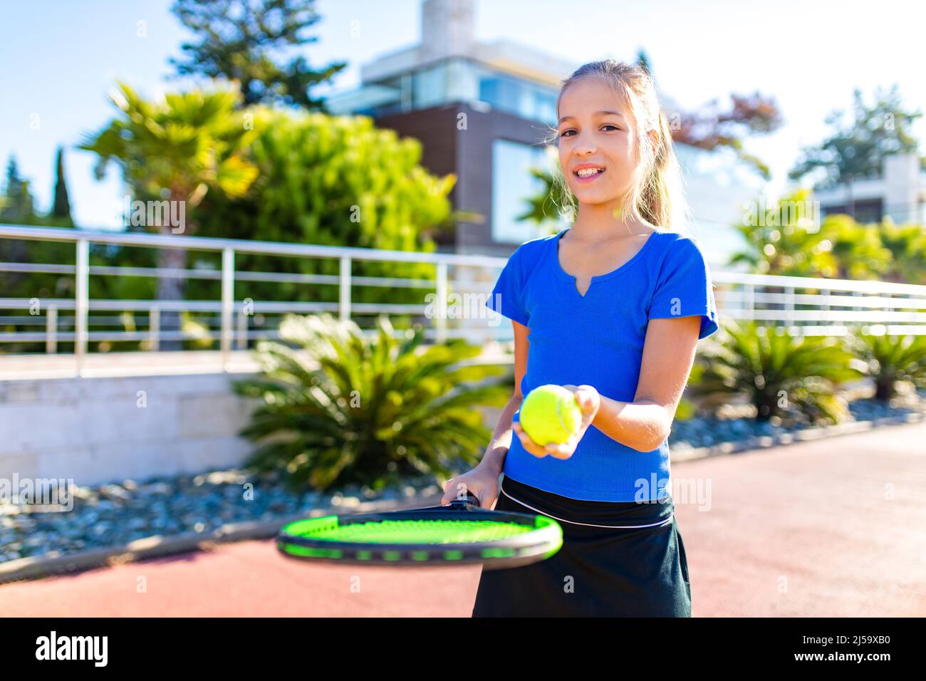 petite girk jouant au tennis dans un endroit tropical à l'extérieur Banque D'Images