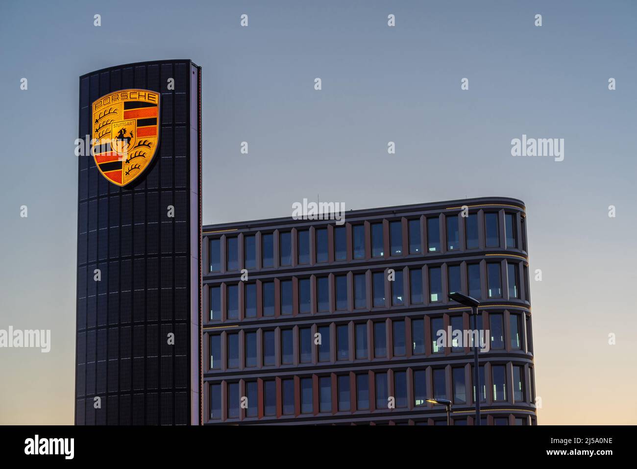 Enseigne Porsche illuminée et bâtiment moderne chez le concessionnaire Porsche Adlershof en Allemagne, Europe Banque D'Images