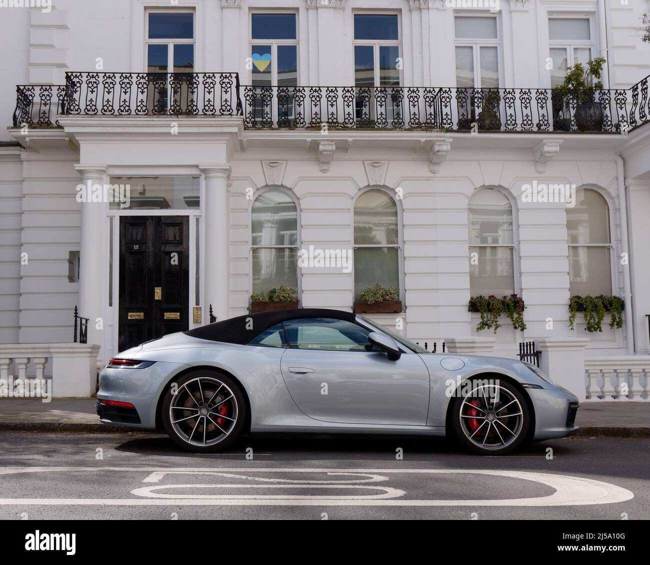 Londres, Grand Londres, Angleterre, avril 09 2022 : voiture Porsche convertible devant une élégante propriété de Notting Hill avec un symbole de coeur dans la fenêtre. Banque D'Images