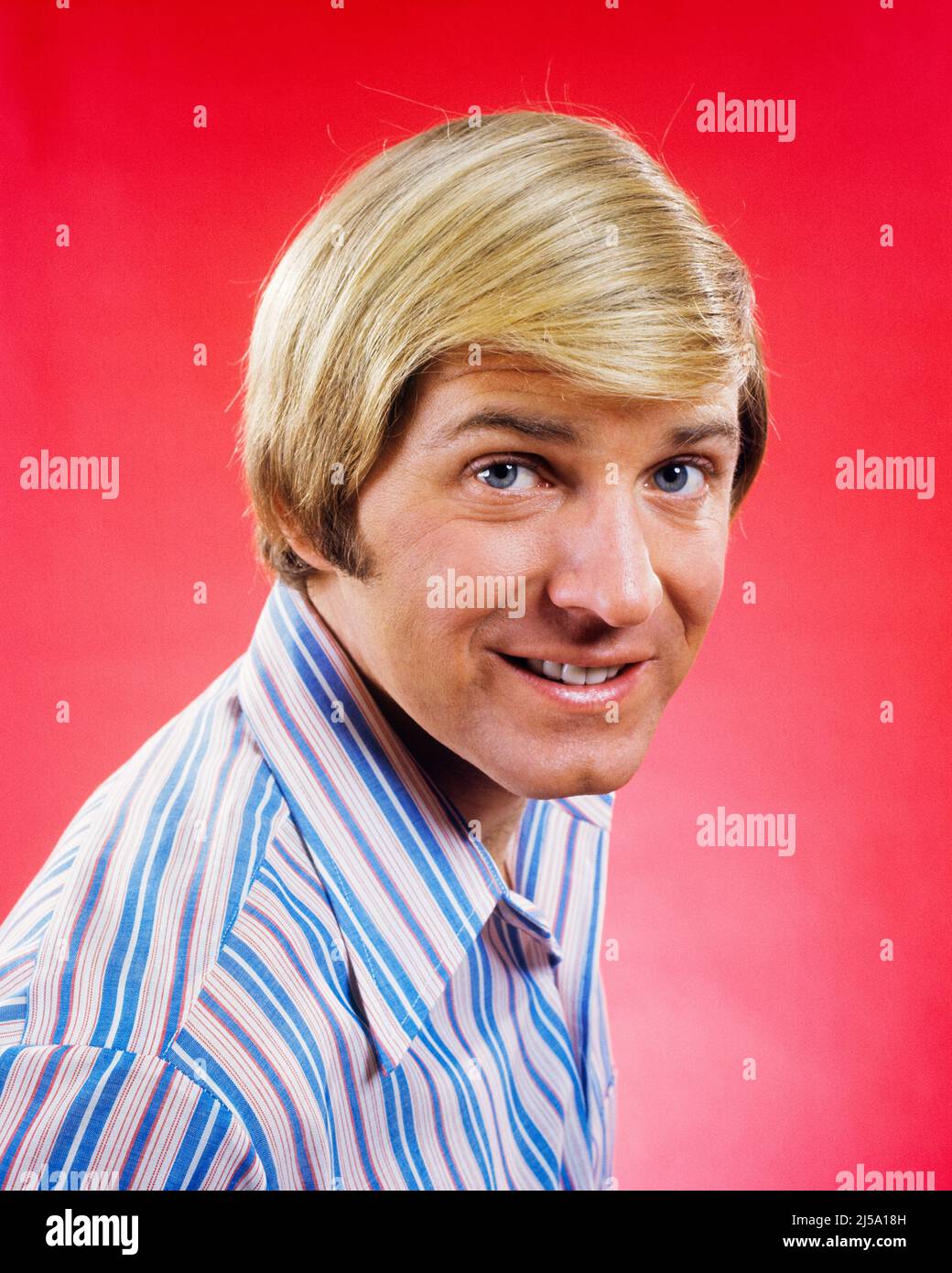 1960S 1970S PORTRAIT D'UN HOMME BLOND SOURIANT AVEC UNE COIFFURE BLONDE LONGUE REGARDANT L'APPAREIL PHOTO PORTANT UNE CHEMISE À RAYURES BLEUES ET BLANCHES - KP1900 HAR001 RAYURES HARS CONTACT VISUEL BONHEUR TÊTE ET ÉPAULES GAIES STYLES COIFFURE SOURIRES JOYEUX STYLE HUTCH MODE HOMME MOYEN-ADULTE HOMME D'ORIGINE CAUCASIENNE PEIGNE PLUS DE HAR001 ANS Banque D'Images