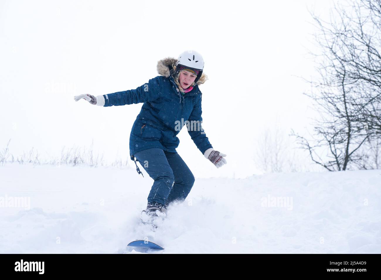 Une fille fait du snowboard depuis la montagne Banque D'Images