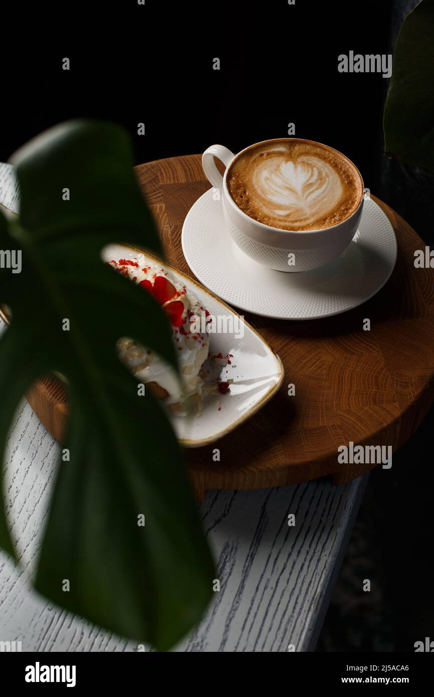 Tasse blanche de café latte chaud avec belle texture latte mousse de lait isolée sur fond sombre. Vue de dessus, espace de copie. Publicité pour café Banque D'Images