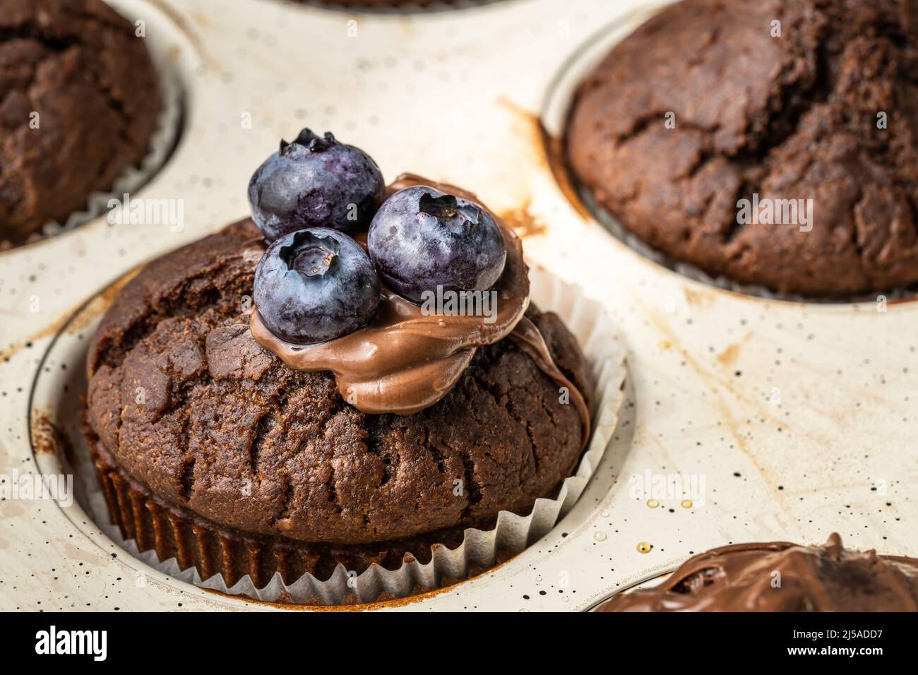 muffins frais avec crème au chocolat et bleuets dans une casserole en céramique Banque D'Images