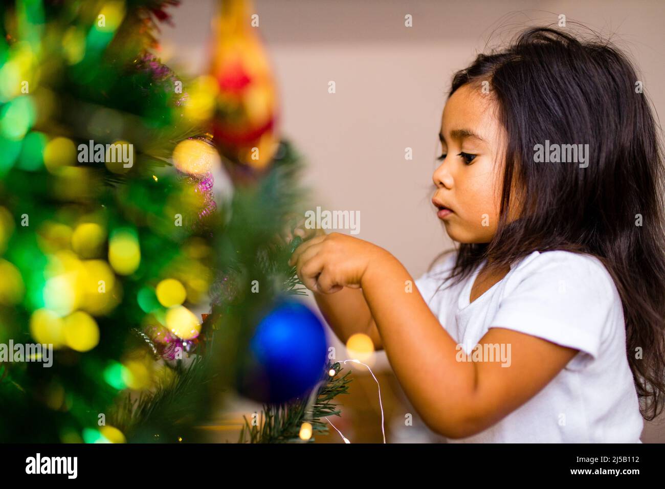 race mixte petite fille mignonne éveillé dans le matin de noël dans la chambre à coucher et en souhaitant un souhait Banque D'Images