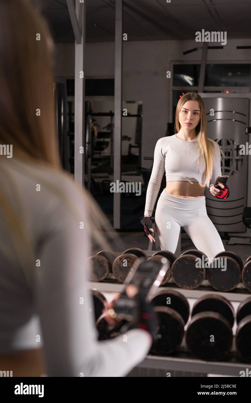 sport, fitness, style de vie, technologie et concept de personnes - jeune  femme avec smartphone faisant selfie en utilisant son smartphone dans la  salle de gym près du miroir Photo Stock - Alamy
