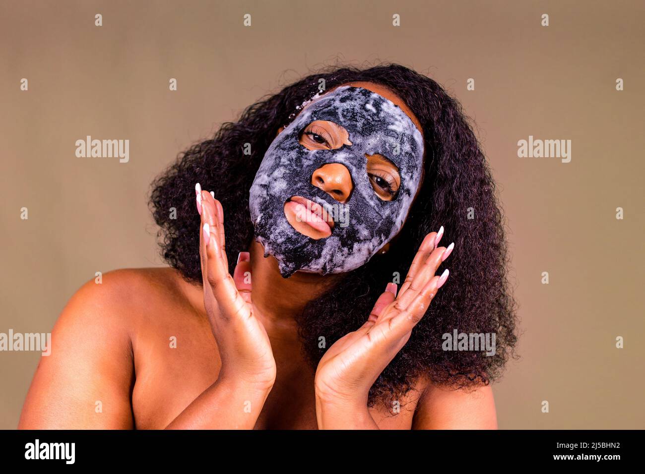 Jeune femme avec masque bulle sur son visage sur fond marron Banque D'Images