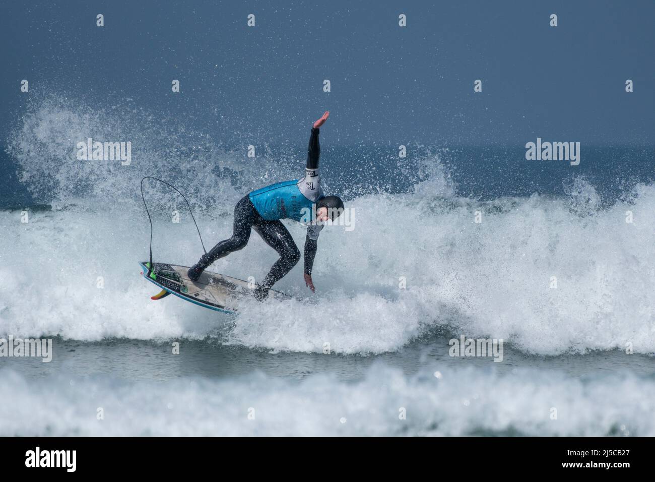 Un surfeur masculin en compétition de surf à Fistral à Newquay, en Cornouailles, au Royaume-Uni. Banque D'Images