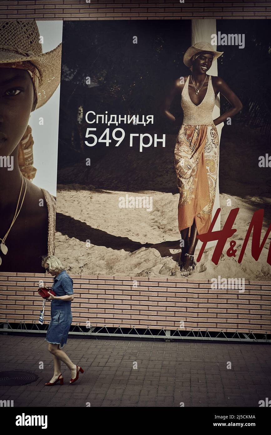 Une dame devant une affiche publicitaire | Une dame devant une affiche publicitaire [traduction automatique] Banque D'Images