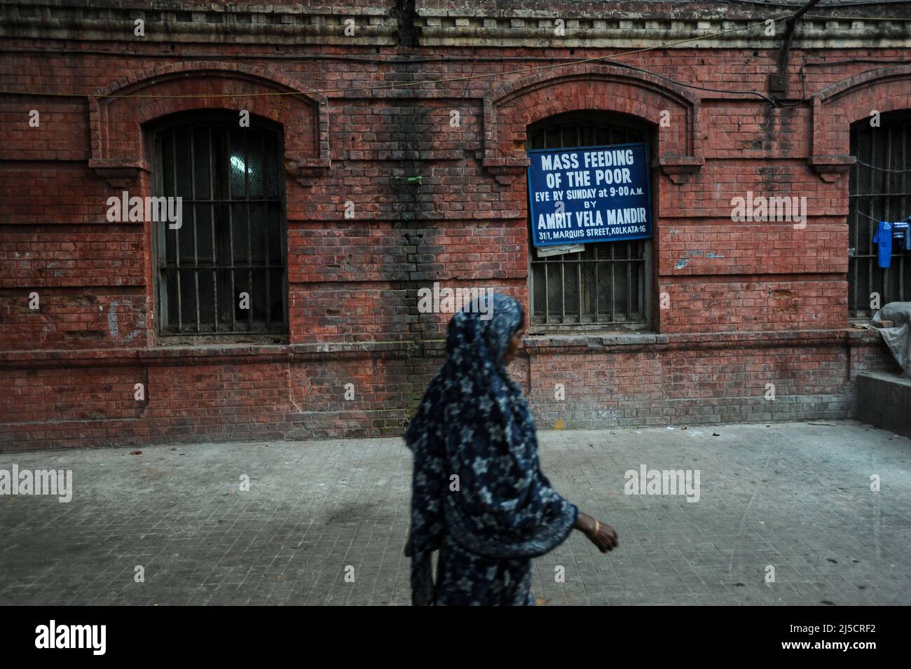 01.12.2011, Kolkata (Calcutta), Bengale-Occidental, Inde, Asie - Une femme passe devant le point de distribution en bord de route d'Amrit Vela Mandir (Langar) dans la zone du nouveau marché, où la nourriture est distribuée aux pauvres et aux nécessiteux chaque dimanche, organisée par les dévotés du temple. [traduction automatique] Banque D'Images