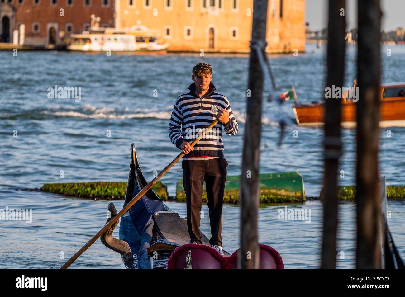 Les gondoles sont une forme de transport d'eau très appréciée, même si elle est chère. Les canaux sont les artères principales qui portent toutes les formes de transport de l'eau - Venise au début de la Biennale di Venezia en 2022. Banque D'Images