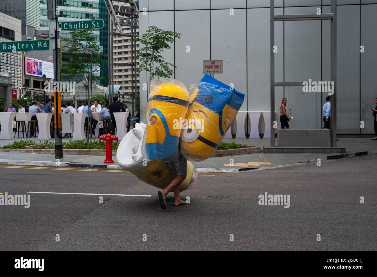 23 août 2018, Singapour, République de Singapour, Asie - Un homme descend une rue à Raffles place, dans le centre-ville, portant des costumes à demi-corps de 3D personnages de film d'animation Minions. [traduction automatique] Banque D'Images