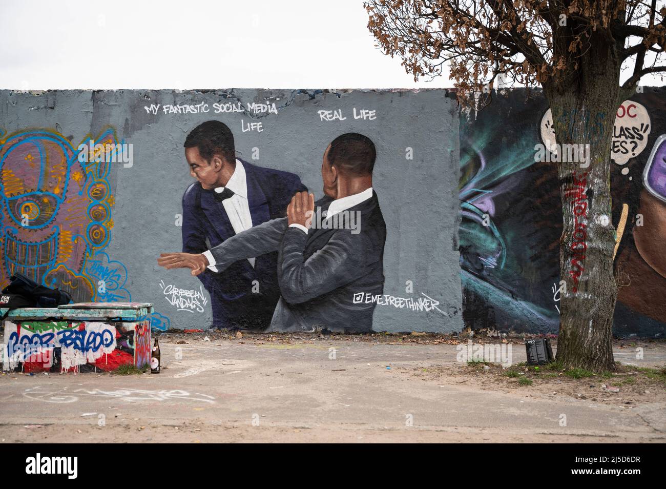 '30.03.2022, Berlin, Allemagne, Europe - Un graffiti de l'artiste Eme Freethinker sur un segment du mur de Berlin dans le Mauerpark de Berlin, dans le quartier de Prenzlauer Berg, montre l'acteur Will Smith qui claque le comédien Chris Rock lors des Academy Awards 94th après avoir fait du plaisir à son épouse Jada Pinkett Smith. Will Smith remporte plus tard le premier Oscar de sa carrière pour le rôle du père des joueurs de tennis venus et Serena Williams dans le film ''King Richard''. [traduction automatique]' Banque D'Images