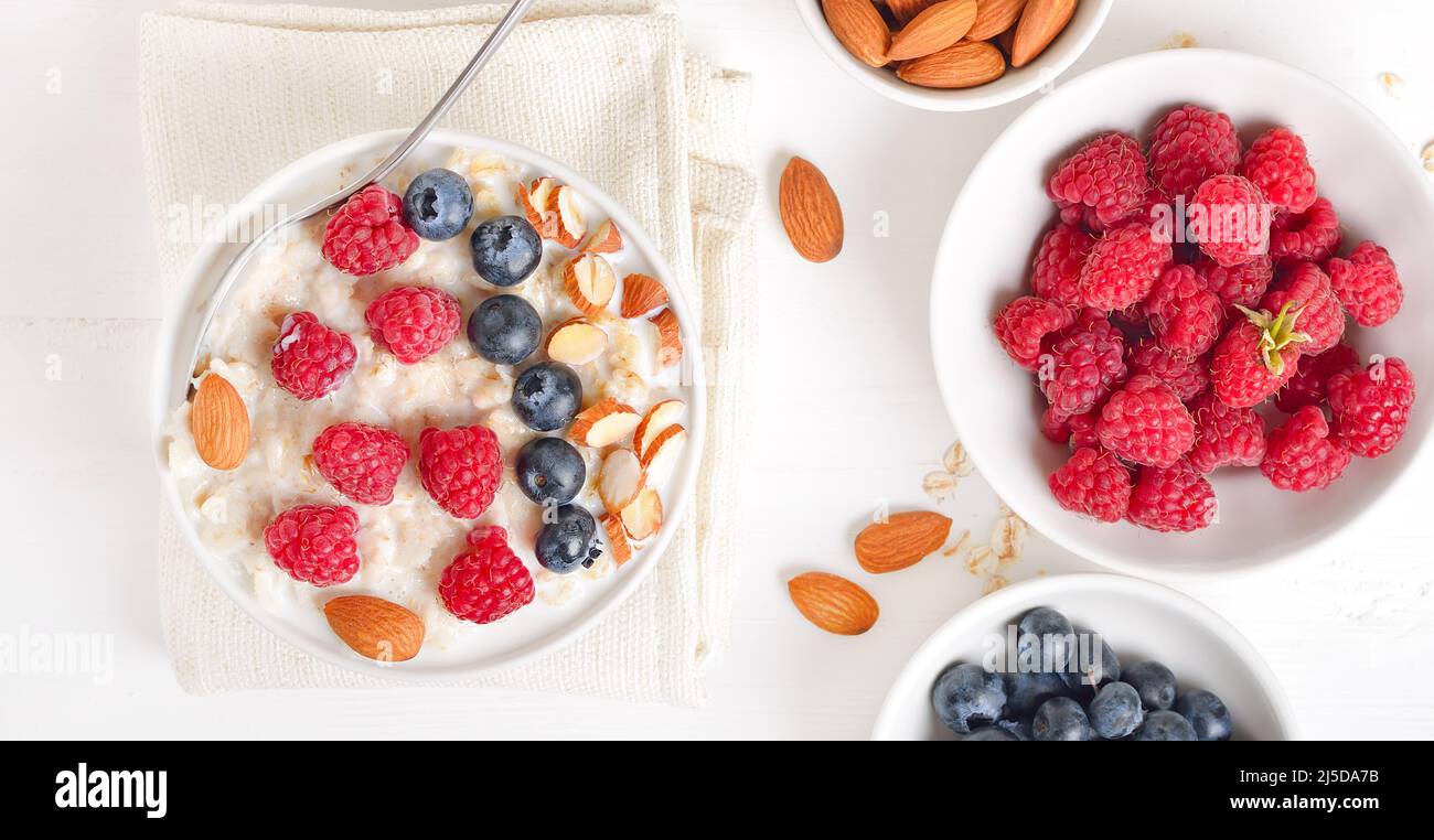 Porridge de flocons d'avoine avec framboises, bleuets et noix dans un bol. Vue de dessus, plan d'appartement Banque D'Images