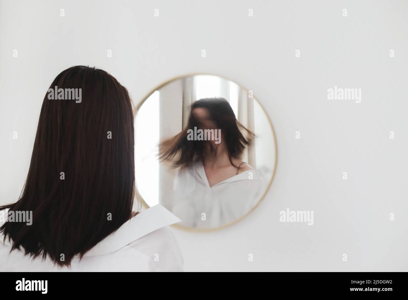 jeune femme regardant dans le miroir. Problèmes de santé mentale dans l'auto-isolement à la maison. Dépression, anxiété, phobie, suicide et concept de santé mentale. Banque D'Images