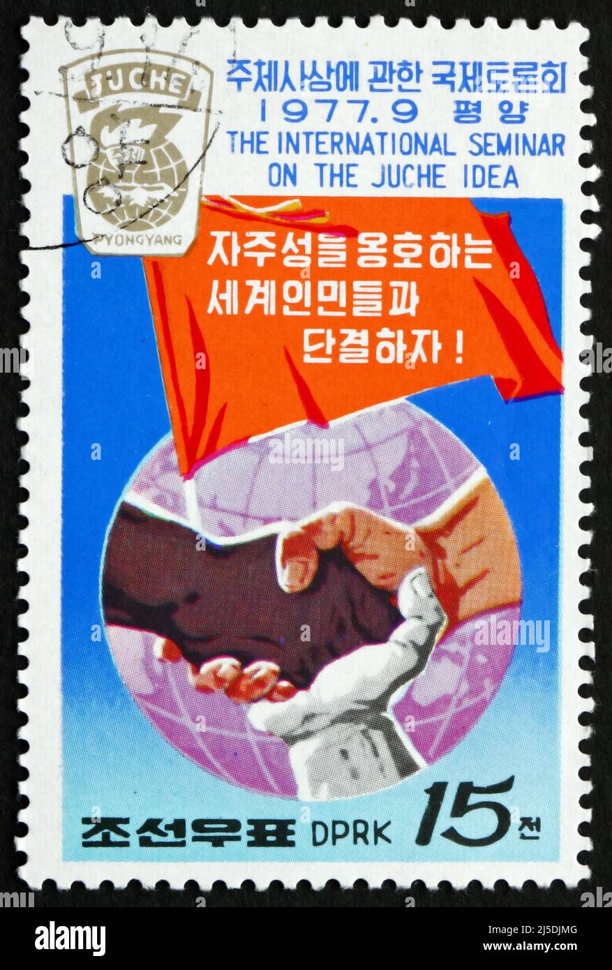 CORÉE DU NORD - VERS 1977 : un timbre imprimé en Corée du Nord montre des mains jointes de différentes races, Banner et Globe, vers 1977 Banque D'Images