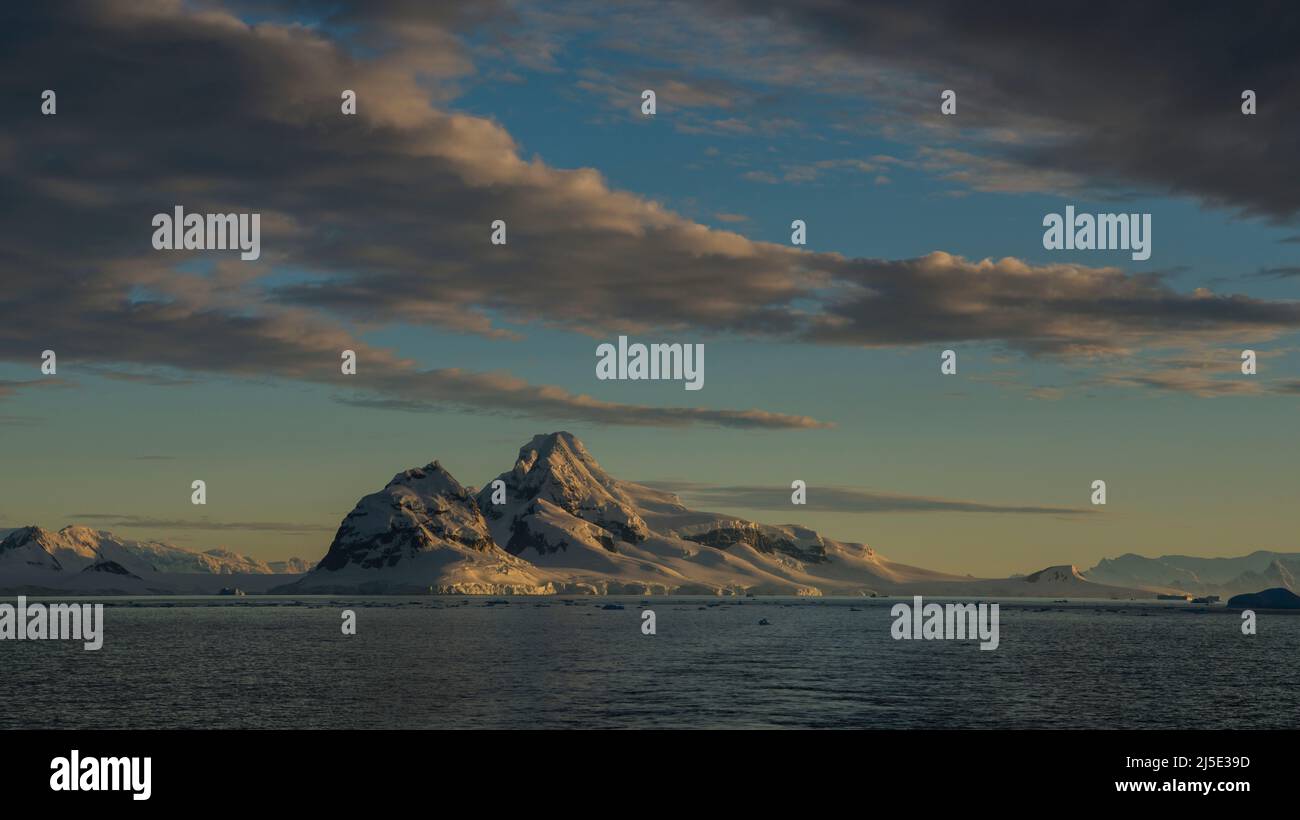 Paysage polaire impressionnant avec des eaux calmes, des glaciers, des montagnes et le lever du soleil, l'Antarctique Banque D'Images