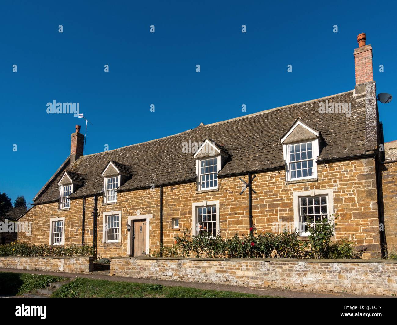 'The Cottage', une jolie maison de campagne en pierre sur South View à Uppingham avec ciel bleu clair au-dessus, Rutland, Angleterre, Royaume-Uni. Banque D'Images