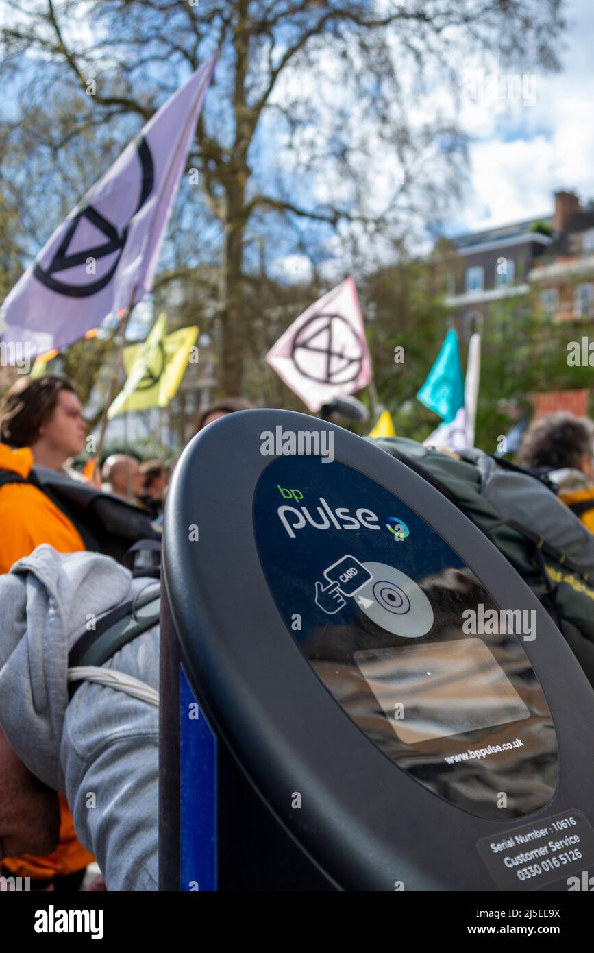 Extinction les manifestants de la rébellion passent devant un point de recharge de voiture électrique BP Pulse, se dirigeant vers le siège de BP pour protester contre les combustibles fossiles Banque D'Images