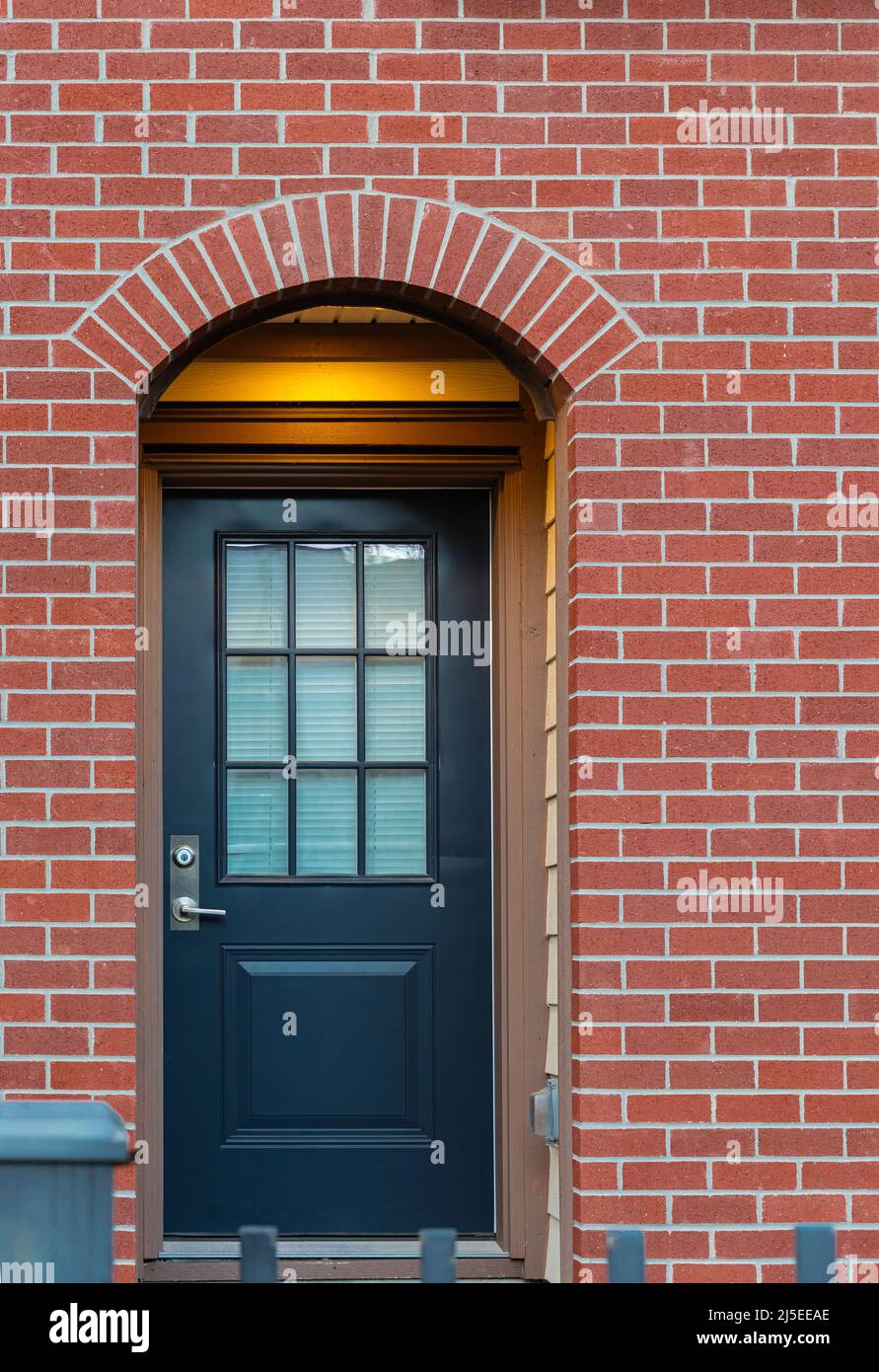 Mur en brique rouge avec belle porte marron. Exteriror d'une maison. Entrée d'une belle maison familiale. Banque D'Images