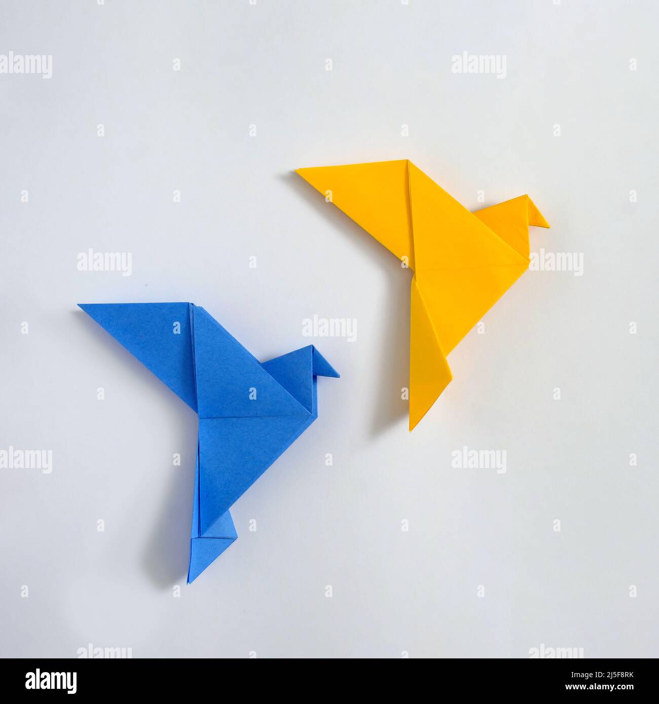 L'origami japonais colombes de la paix jaune et bleu concept de paix et d'aide dans le conflit en Ukraine et affiche papier de passe-temps et de divertissement. Banque D'Images