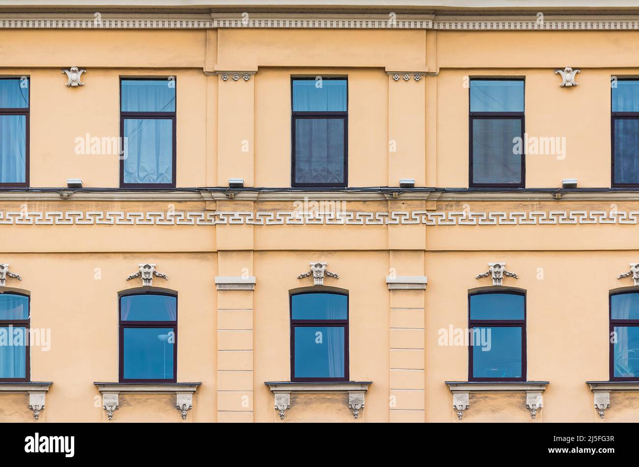 De nombreuses fenêtres d'affilée sur la façade de l'immeuble urbain historique d'appartements vue de face, Saint-Pétersbourg, Russie Banque D'Images