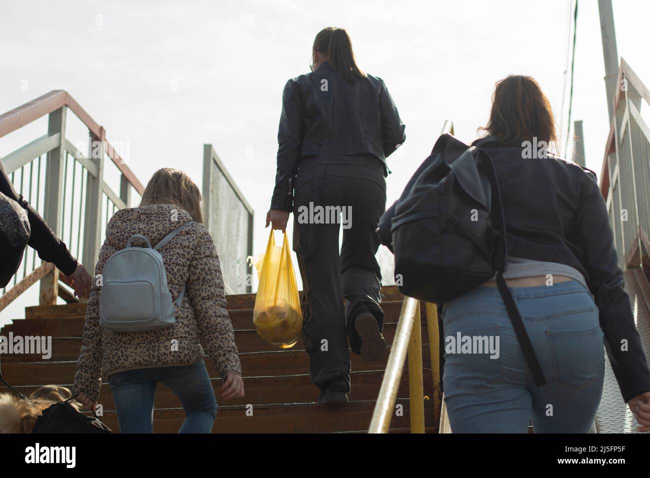 Les gens monter les escaliers. Les femmes avec des sacs et des lunettes vont. Les passagers grimpent au passage piéton. Banque D'Images