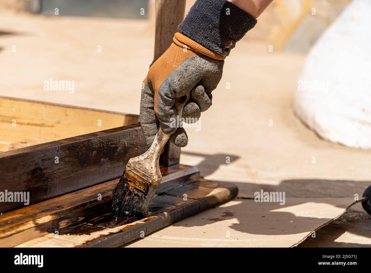 Homme travaillant sur la restauration des anciennes forniture à l'aide de bitume judaicum. Concept de l'entretien du bois et de l'imperméabilisation Banque D'Images