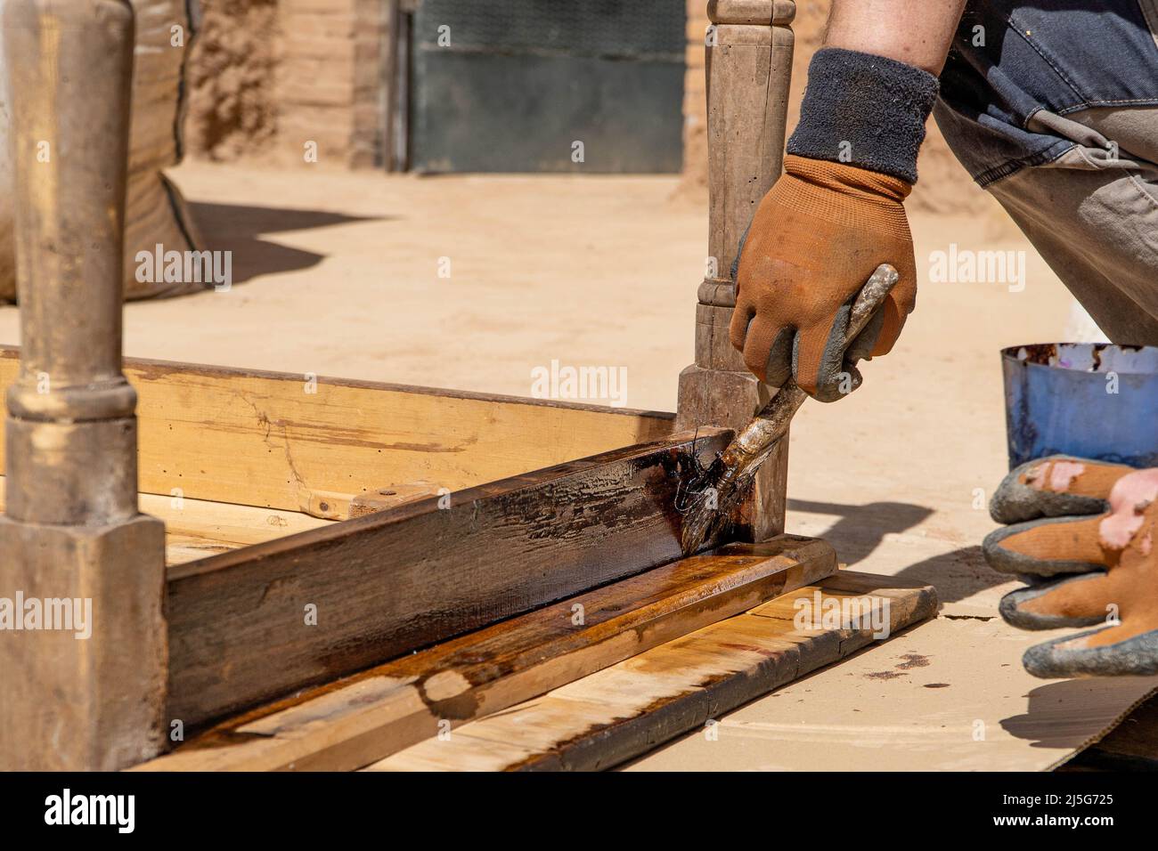 Homme travaillant sur la restauration des anciennes forniture à l'aide de bitume judaicum. Concept de l'entretien du bois et de l'imperméabilisation Banque D'Images