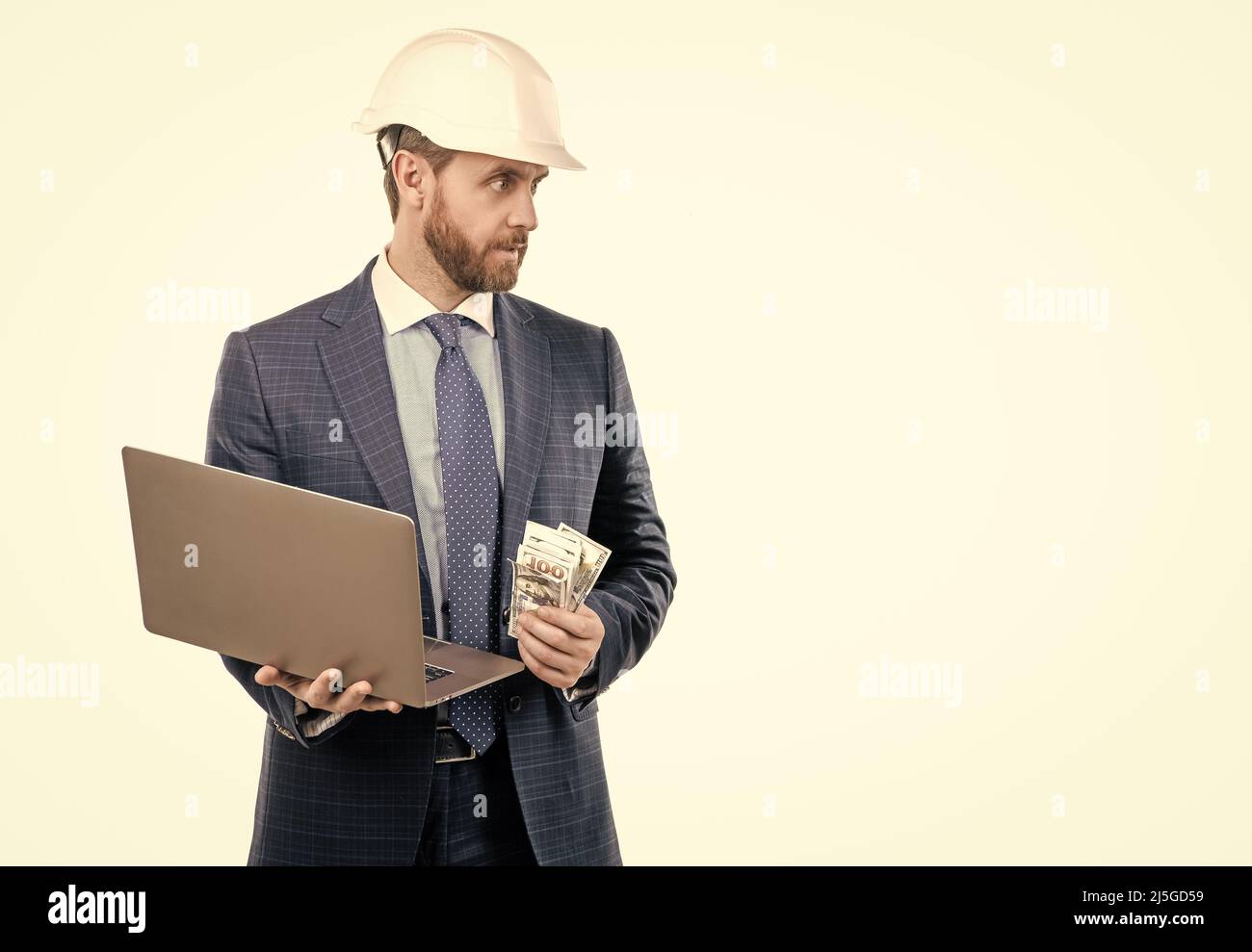 Homme ingénieur professionnel en casque et costume tenir l'argent et l'ordinateur portable, coût de travail Banque D'Images