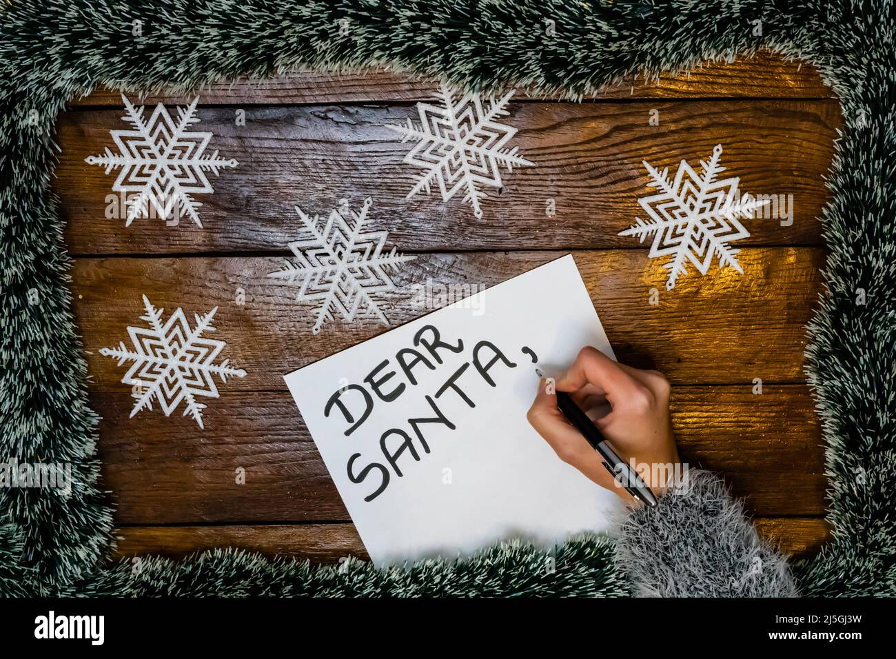 La main lettre pour le Père Noël. Cher Père Noël écrit sur papier