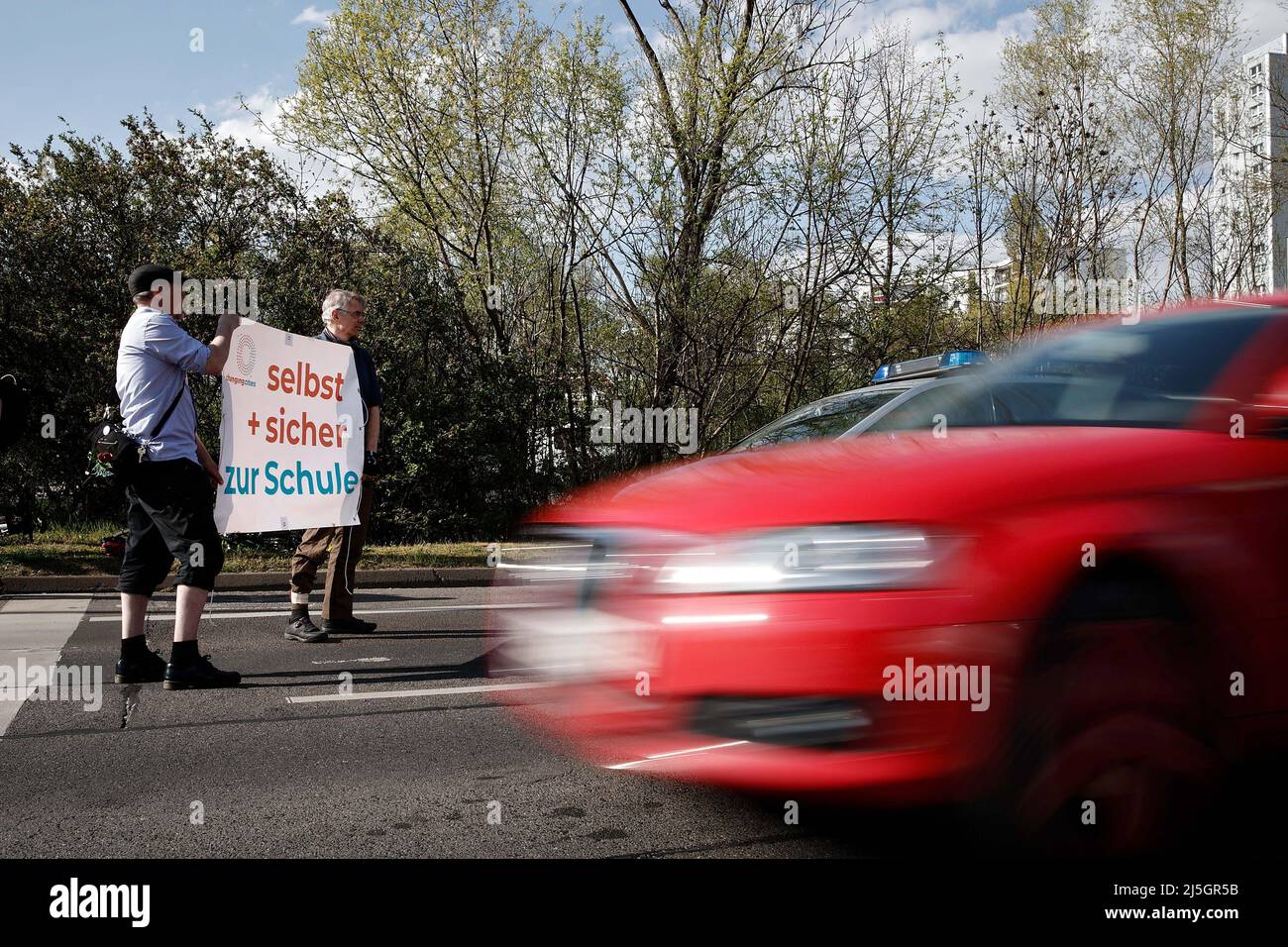 Berlin, Allemagne. 23rd avril 2022. Les participants d'une vigile tiennent une affiche avec l'empreinte 'self safe to School' sur la rue Landsberger Allee. L'action visait à attirer l'attention sur la mort d'un enfant de 11 ans après un accident de la route. Credit: Carsten Koall/dpa/Alay Live News Banque D'Images