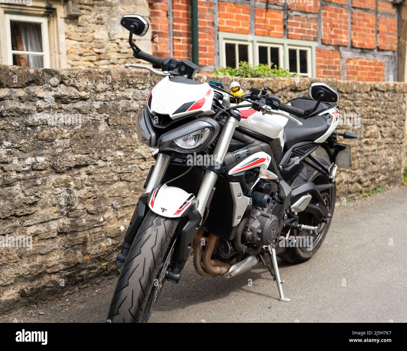 White triomphe Street triple S moto garée dans un village de 18th siècle rue Lacock Wiltshire Banque D'Images