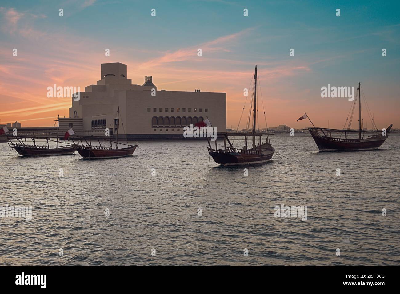 Musée d'art islamique à Doha, Qatar vue extérieure du coucher du soleil montrant l'architecture unique du musée avec des huws dans le golfe arabe en premier plan Banque D'Images