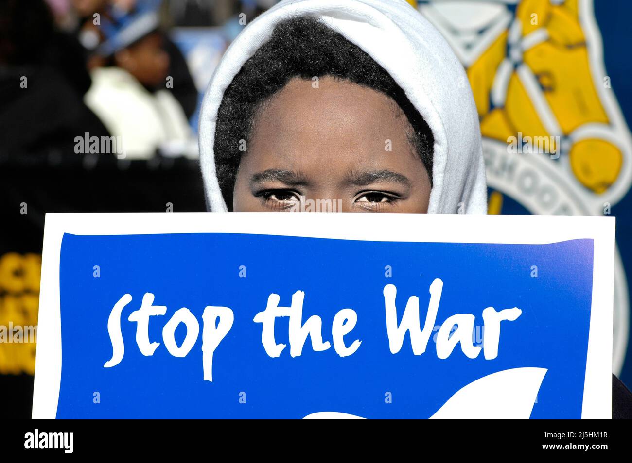 Jeune garçon noir ethnique au rassemblement de manifestation anti-guerre à Atlanta, en Géorgie, regardant la caméra avec le signe Stop the War Banque D'Images