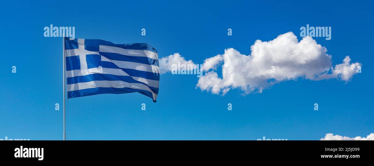 Drapeau officiel national grec sur le mât agitant dans le vent. Symbole de la Grèce. Ciel bleu avec nuage, jour de printemps ensoleillé à Athènes. Banque D'Images