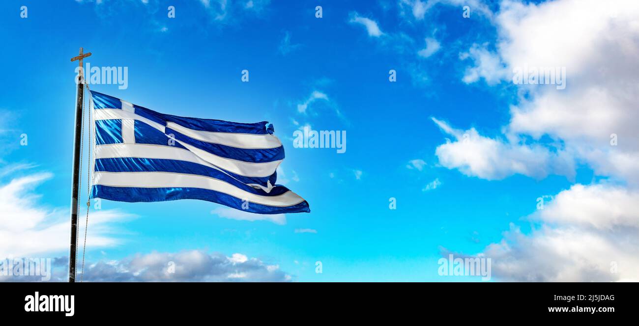 Symbole de la Grèce. Drapeau officiel national grec sur le mât agitant dans le vent. Ciel bleu avec nuage, jour de printemps ensoleillé à Athènes. Banque D'Images