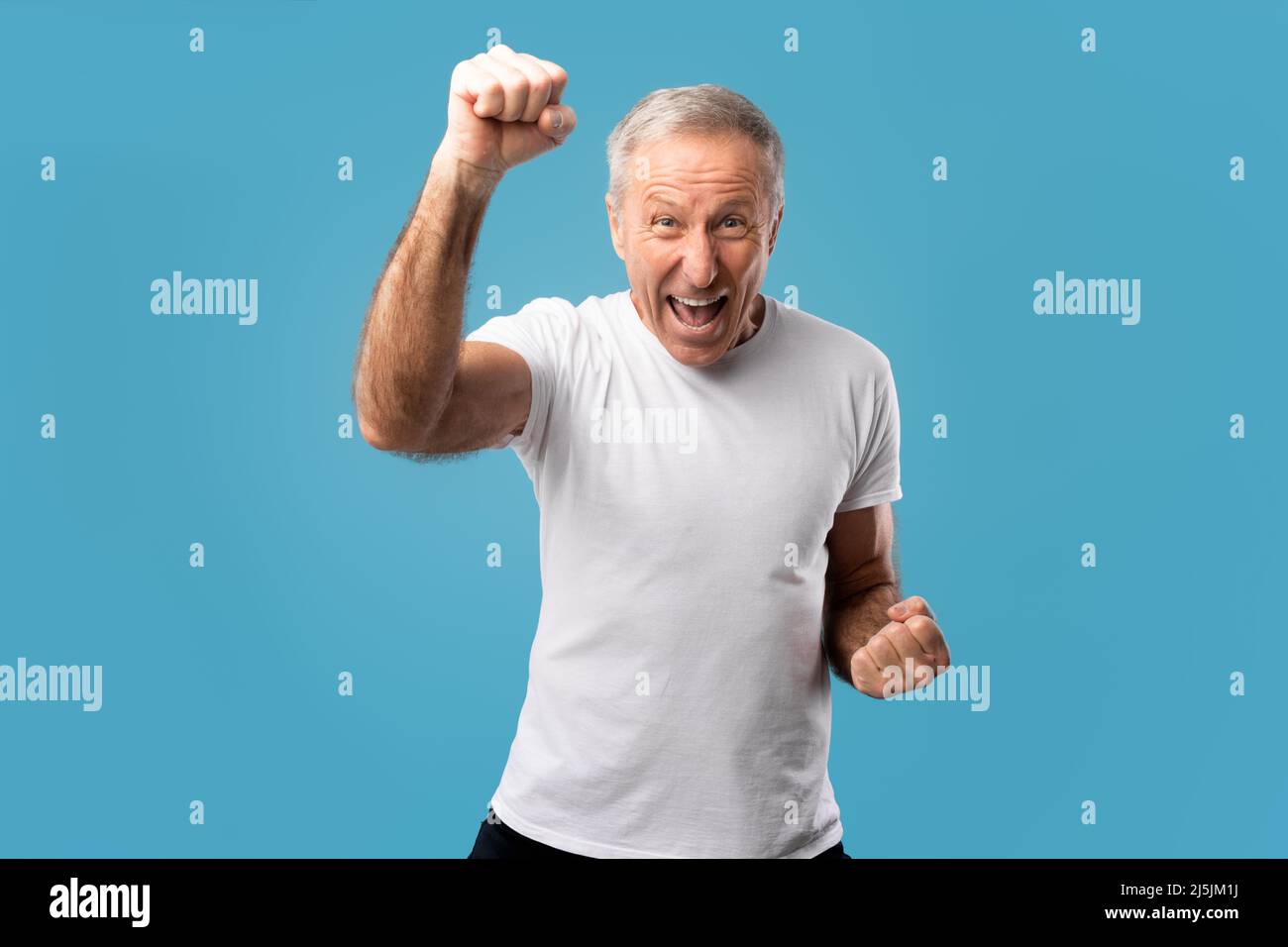 Portrait d'un homme mûr excité criant des poings secouants Banque D'Images