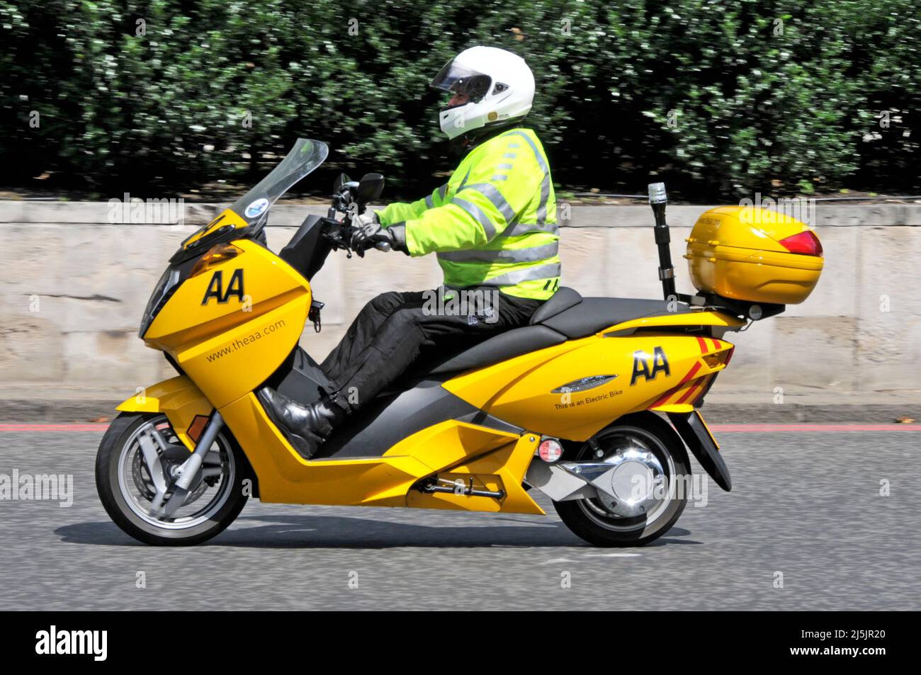Vue latérale AA Patrolman veste haute visibilité équitation jaune scooter électrique vélo donner aux membres l'assistance routière dans les rues encombrées de Londres Angleterre Royaume-Uni Banque D'Images