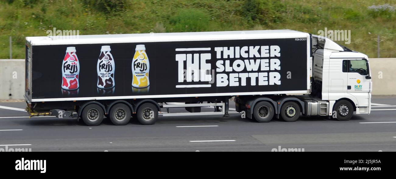 Vue latérale blanc Dairy Crest camion hgv et long remorque articulée noire publicité graphique Muller Frijj milkshake beunits boisson bouteilles UK autoroute Road Banque D'Images