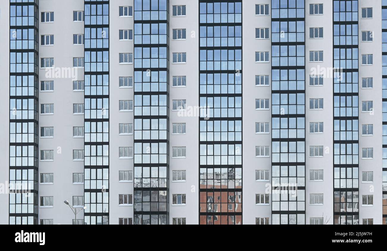 Vue de face du nouveau bâtiment résidentiel de haute hauteur avec de nombreuses fenêtres en hiver Banque D'Images