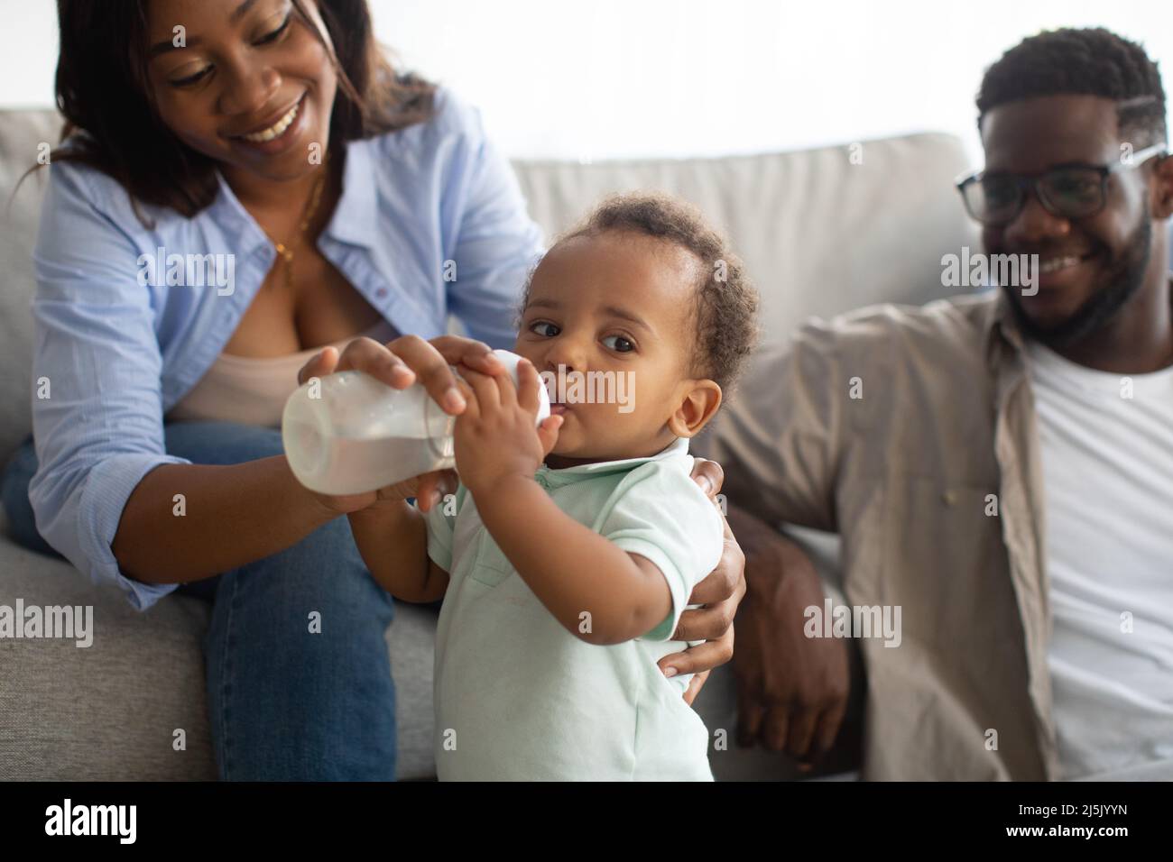 Jeunes parents afro-américains qui allaitent l'enfant au biberon Banque D'Images