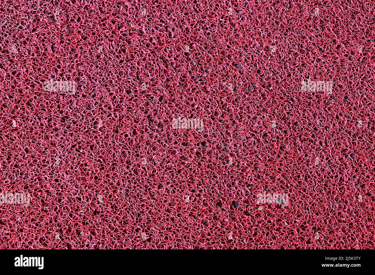 Arrière-plan texturé de tapis synthétique rouge Banque D'Images