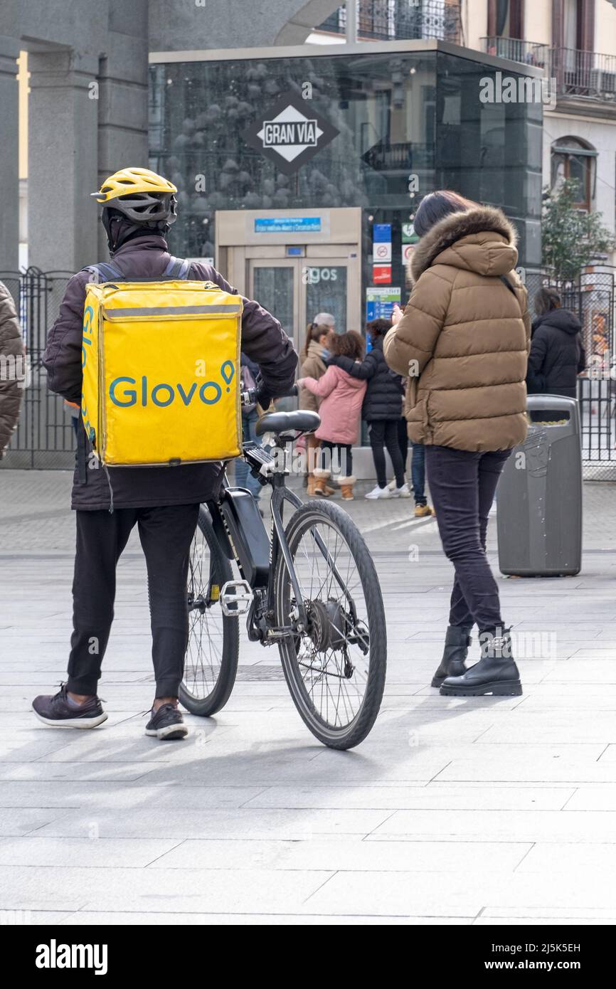 Madrid, España - Enero 8 2022: Mensajero con mochila amarilla y bicicleta por las de Madrid Photo Stock - Alamy