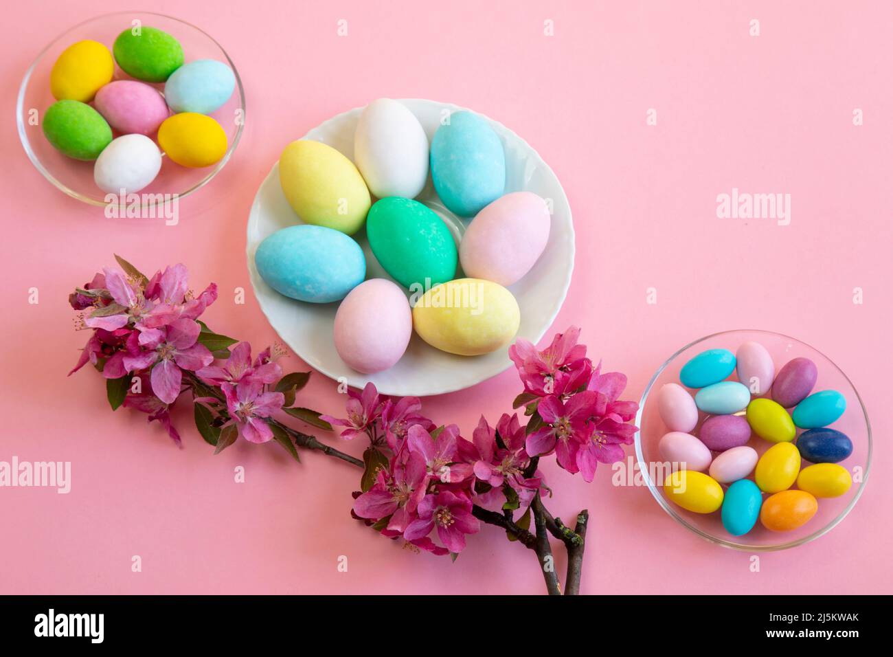 Joyeuses Pâques ! Carte de Pâques avec une photo d'oeufs colorés avec des oeufs de poule, de pigeon et de caille décorés de fleurs sur fond rose Banque D'Images